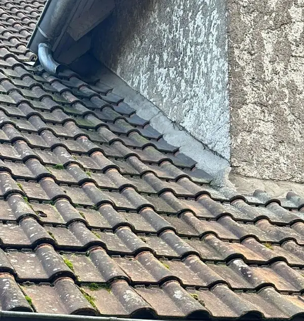 Présence de mousses et lichens sur les tuiles, indiquant la nécessité d’un démoussage, d’un nettoyage et d’un traitement hydrofuge pour sécuriser l’étanchéité.​ Ce visuel illustre un diagnostic de couverture à Versailles dans les Yvelines, idéal pour valoriser des services de réparation de solins, reprise d’étanchéité et entretien de toiture en Île-de-France.