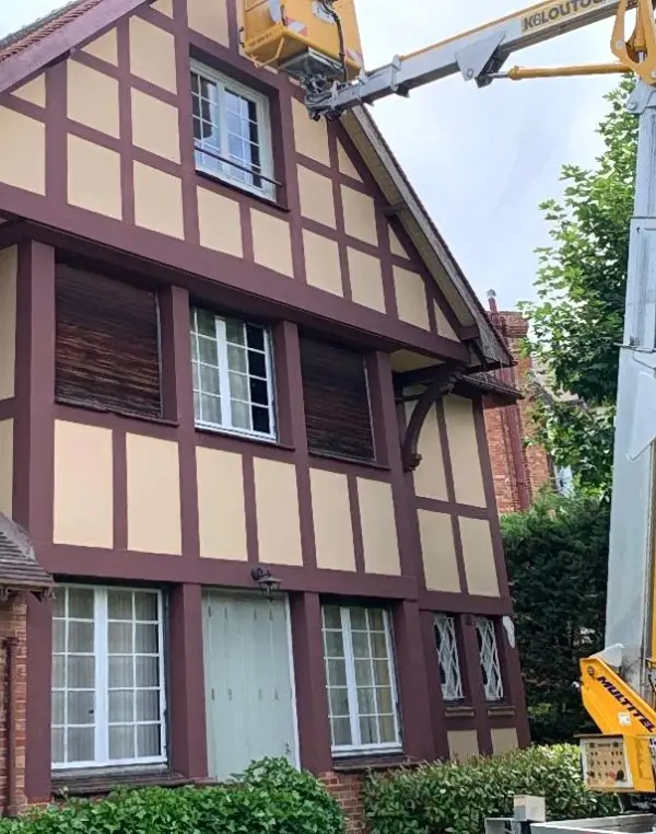 Ravalement et peinture intérieur - extérieur 1 Nacelle devant une façade à colombages ; intervention de ravalement et peinture sur pignon d’une maison à Versailles (Yvelines).