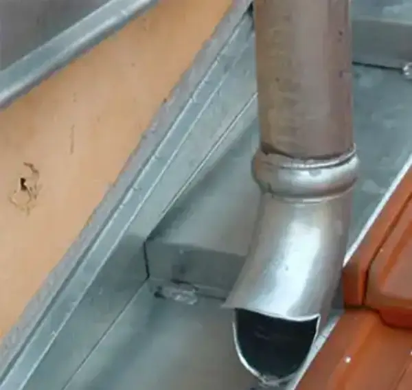 Zinguerie 2 Détail d’une descente EP en zinc avec bec de déversement vers chéneau et solin contre‑mur, près de tuiles, à Versailles (78)