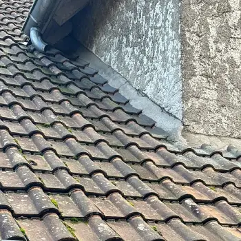 Nettoyage et démoussage 2 Artisan réalisant le nettoyage et le démoussage d'une toiture en tuiles avec un traitement hydrofuge.